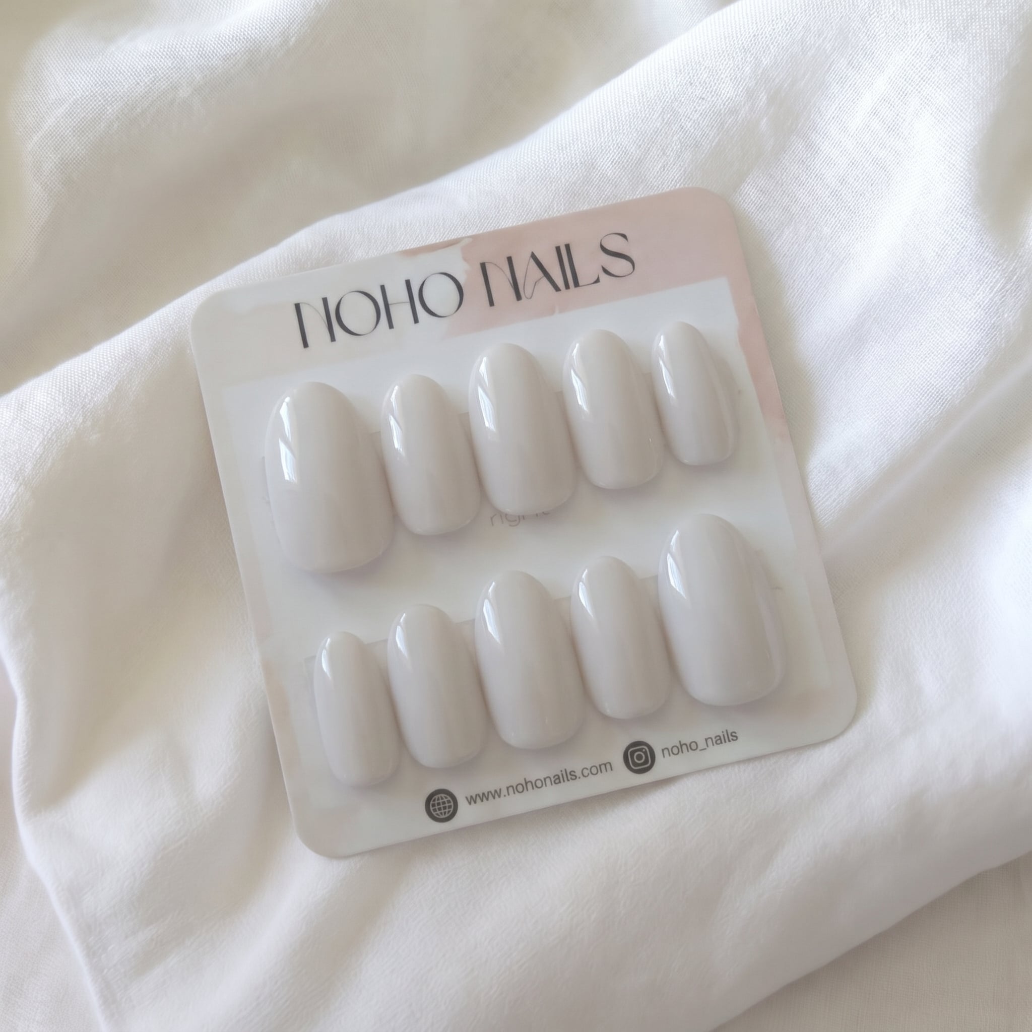 Morning Sighs press-on nails by Noho Nails: ten glossy milky soft-gray almond nails on a Noho Nails display card
