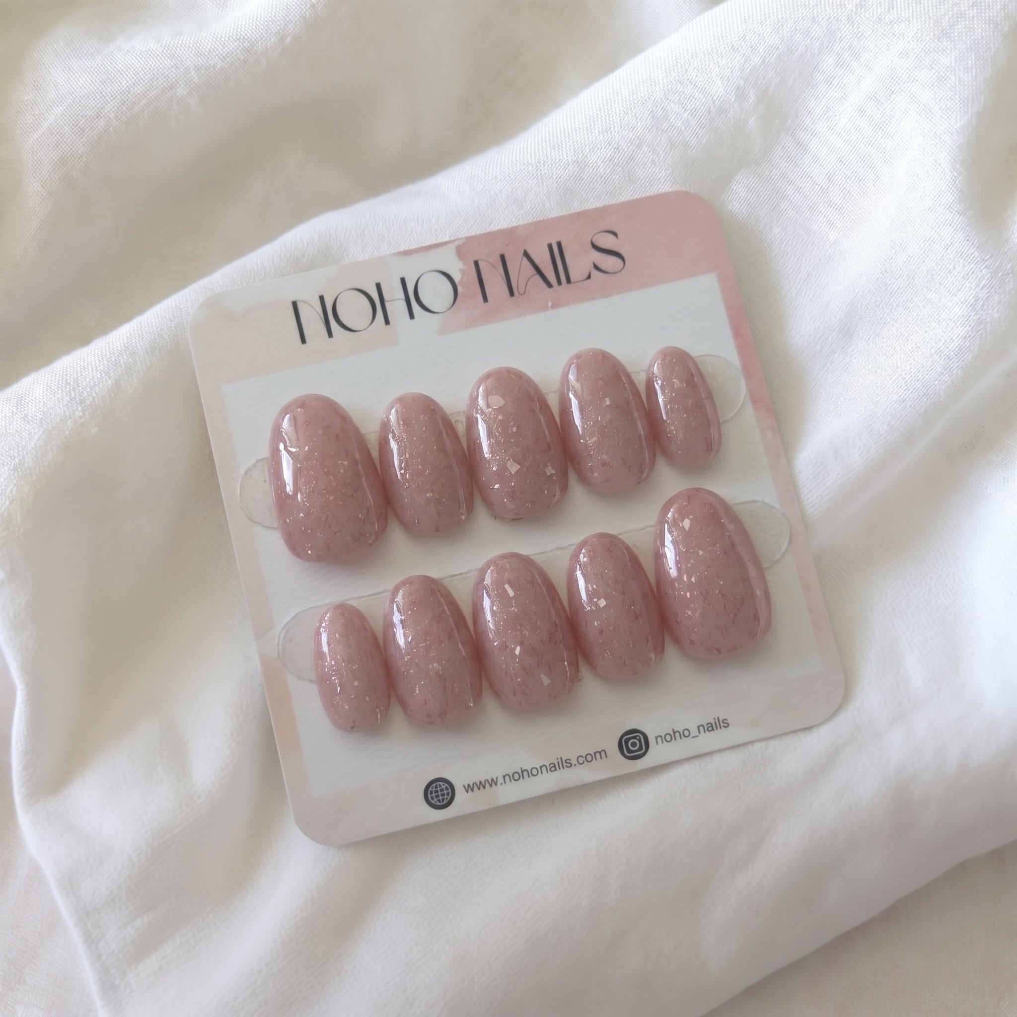 Muted Red Knit press-on nails by Noho Nails: ten glossy dusty rose jelly nails with silver flecks on a Noho Nails display card
