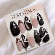 Café de Flore press-on nails by Noho Nails: long almond nails in dark brown cat-eye glitter with white line art, tortoiseshell tips and cream French tips on a Noho Nails display card