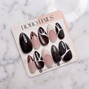 Café de Flore press-on nails on a Noho Nails display card lying on white marble