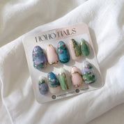 Water Lilies press-on nails by Noho Nails: Monet-inspired painted water lily nails with pale pink and gold accents on a Noho Nails display card