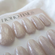 Close-up of Prosecco Pearl press-on nails by Noho Nails: milky blush-pink nails with champagne cat-eye shimmer
